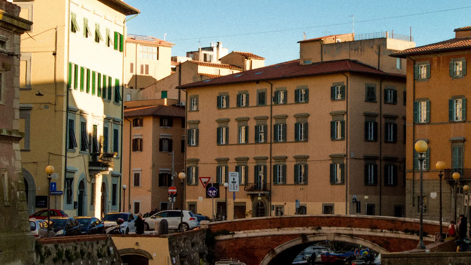 Boats along a canal and historic waterfront buildings in Livorno