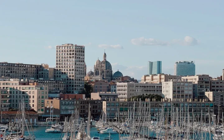 Sailboats in Marseille’s Vieux-Port beneath the city skyline and a domed cathedral