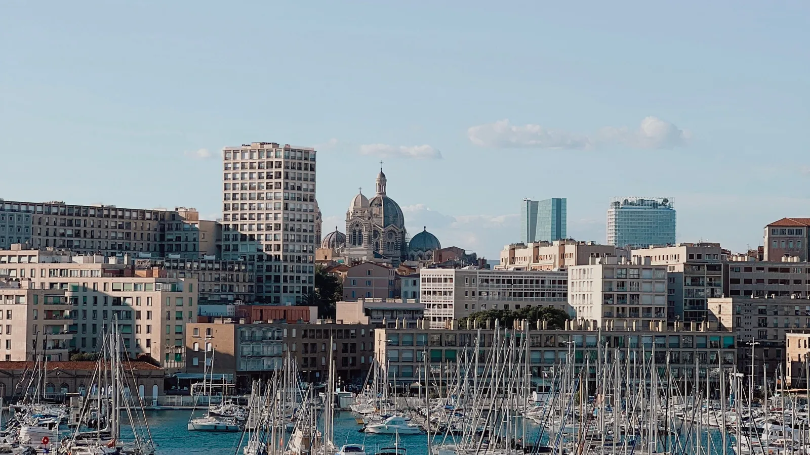 Sailboats in Marseille’s Vieux-Port beneath the city skyline and a domed cathedral