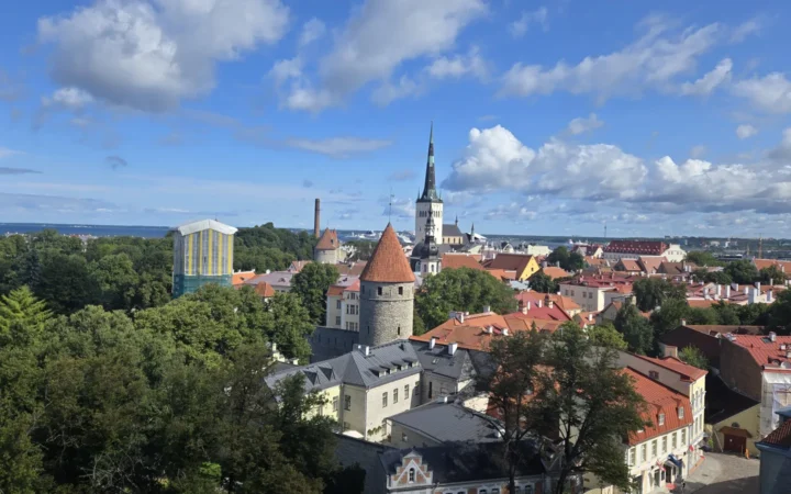 Tallinn old-town rooftops and church towers beneath a blue sky