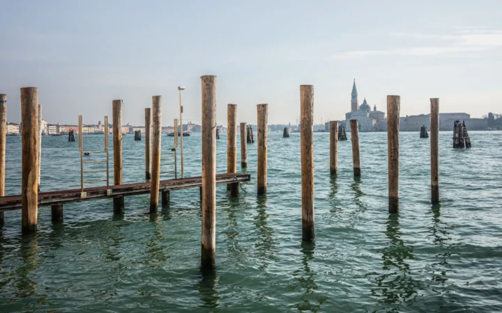 Wooden mooring posts in the Venetian Lagoon with San Giorgio Maggiore in the distance