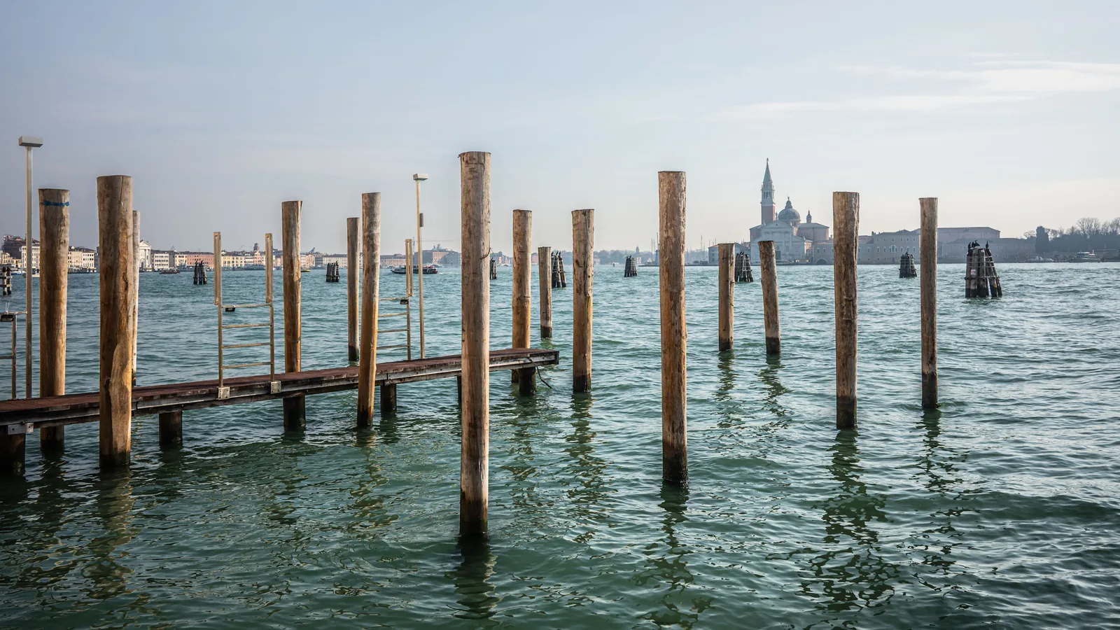 Wooden mooring posts in the Venetian Lagoon with San Giorgio Maggiore in the distance